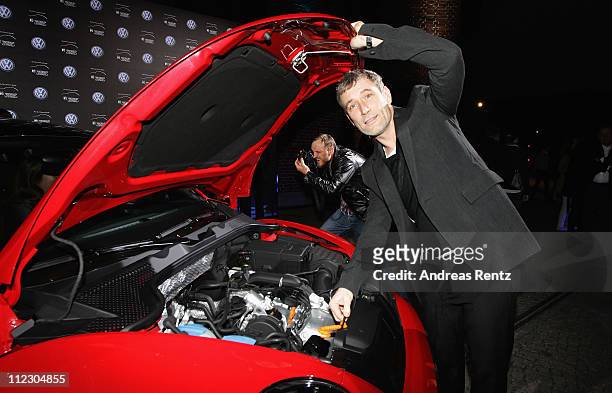 Actor Heikko Deutschmann poses at the Volkswagen New Beetle during the world premiere of the 21st Century Beetle at ewerk on April 18, 2011 in...