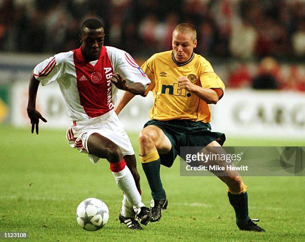 Steve Guppy of Celtic tries to tackle Yakubu Abubakari of Ajax during the UEFA Champions League Third Qualifying Round, First Leg match between Ajax...