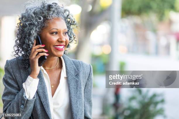 schöne reife schwarze frau am telefon - model business woman stock-fotos und bilder