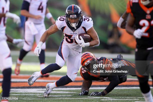 Phillip Lindsay of the Denver Broncos runs the football upfield against Vontaze Burfict of the Cincinnati Bengals during their game at Paul Brown...