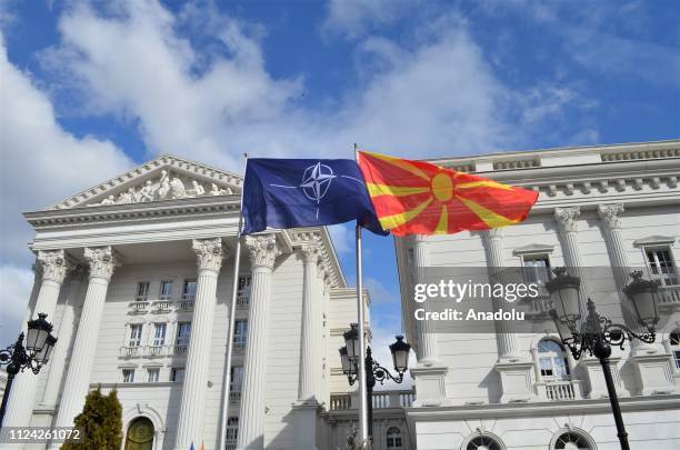 Flags of Macedonia and NATO wave in front of government building in Skopje, Macedonia on February 12, 2019.