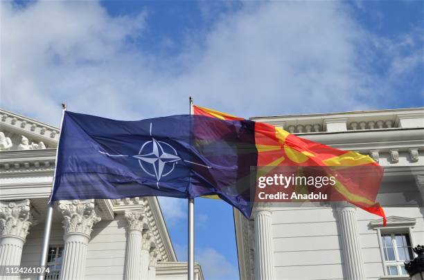 Flags of Macedonia and NATO wave in front of government building in Skopje, Macedonia on February 12, 2019.