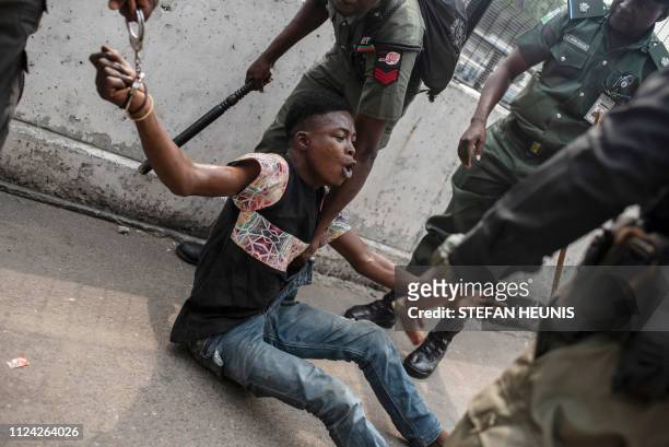 Police detain a suspected thief from the Tafawa Balewa Square in Lagos where the official opposition the People's Democratic Party will hold a rally...
