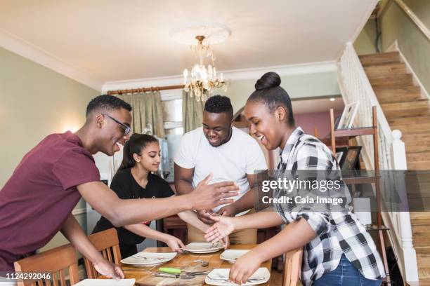happy siblings setting the table - secret handshake stock pictures, royalty-free photos & images