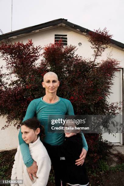 a portrait of a mother with her twin daughters - stanislaus county stock pictures, royalty-free photos & images