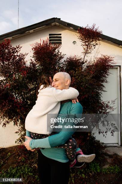 A portrait of a bald woman with her daughter