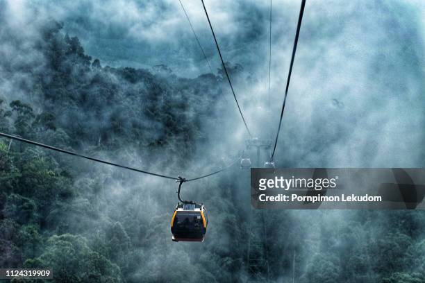 cable car go to top of hill in the mist - cable car stockfoto's en -beelden