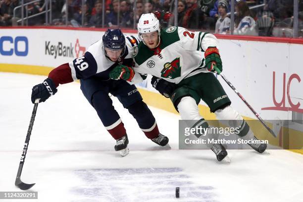 Samuel Girard of the Colorado Avalanche fights for the puck against Pontus Aberg of the Minnesota Wild in the first period at the Pepsi Center on...