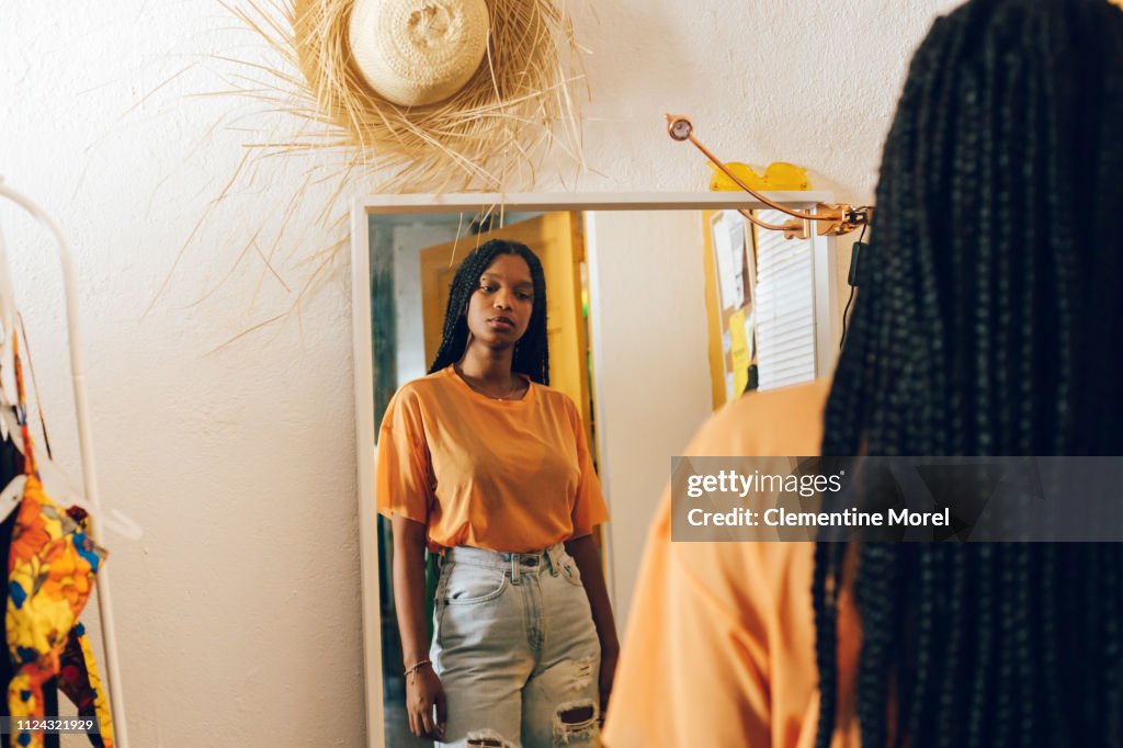 Young woman looking in the mirror