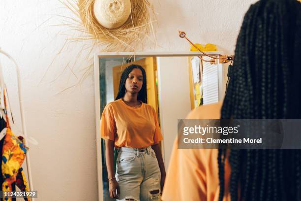 young woman looking in the mirror - see stockfoto's en -beelden