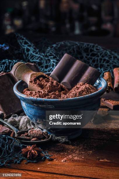 close up of cocoa powder with chocolate bar into a blue bowl in old fashioned style - dark chocolate stock pictures, royalty-free photos & images