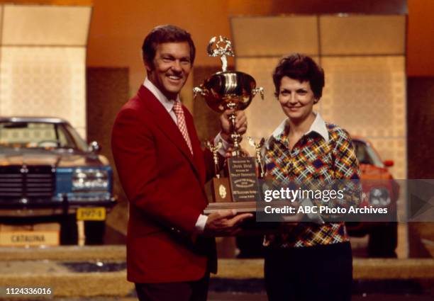 Host Tom Kennedy awarding contestant Joan Diaz trophy on the Walt Disney Television via Getty Images game show 'Split Second'.