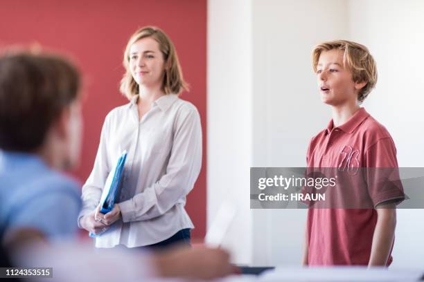 confident schoolboy giving speech in classroom - boy in briefs stock pictures, royalty-free photos & images