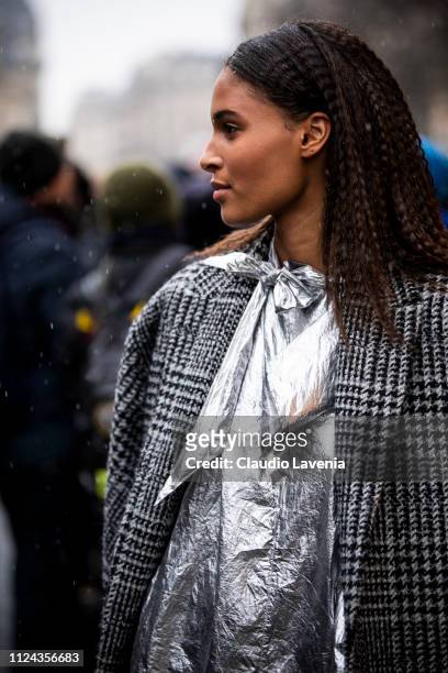 Cindy Bruna, wearing a checked coat and silver mini dress, is seen outside Jean Paul Gaultier show during Paris Fashion Week - Haute Couture Spring...