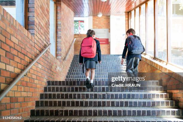 school children with backpacks walking upstairs - school students uniform walking stock pictures, royalty-free photos & images