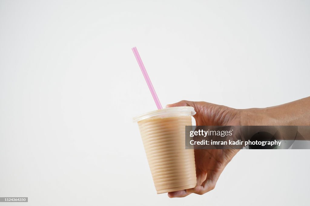The pulled tea or Teh tarik in disposable Plastic PP Cup