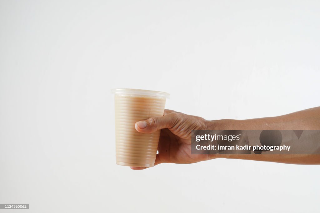 The pulled tea or Teh tarik in disposable Plastic PP Cup