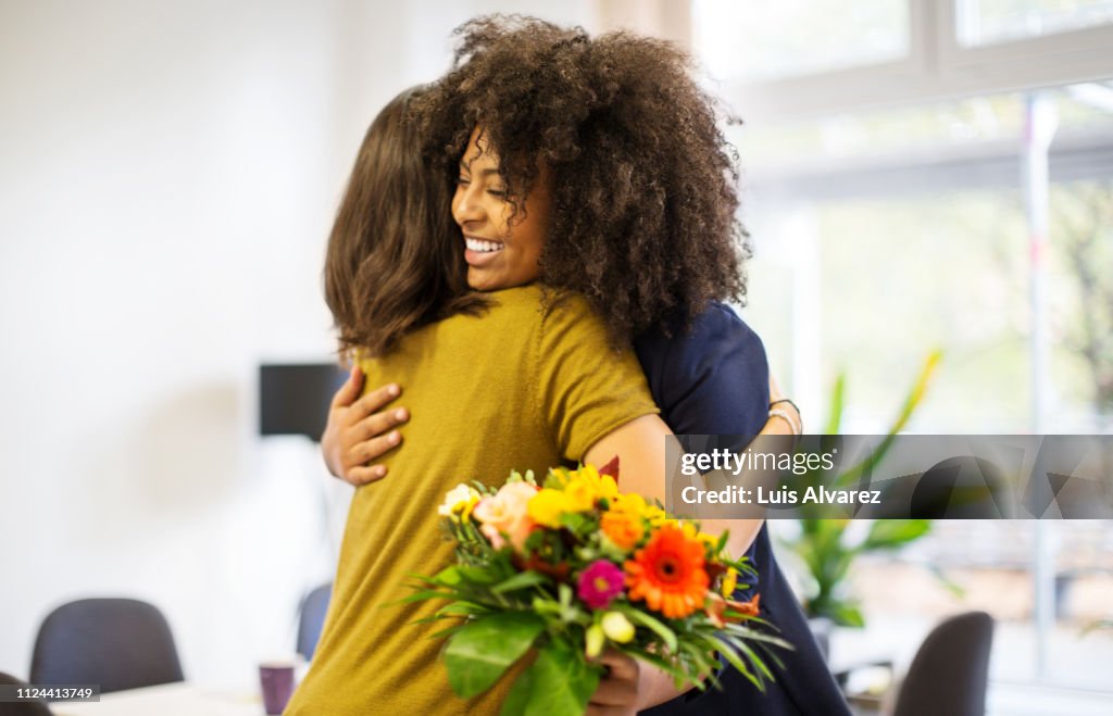 Woman congratulating female coworker over her success