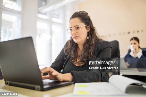 businesswoman busy working on her laptop - italian designers stock-fotos und bilder