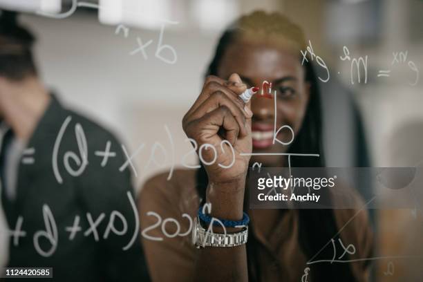 professor writing mathematical formulas on a glass - mathematical symbol stock pictures, royalty-free photos & images