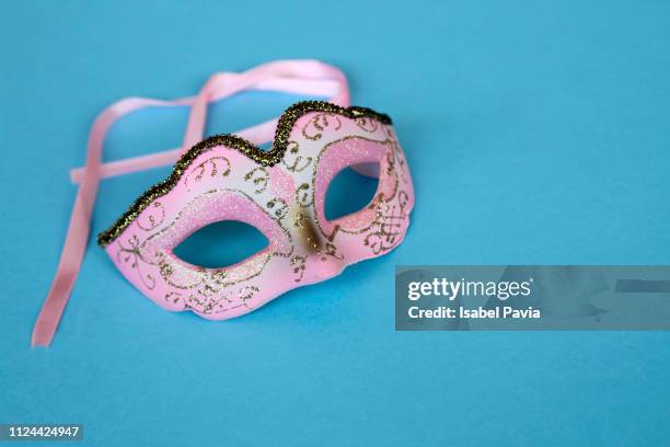 pink mask on blue background - theatermaske stock-fotos und bilder