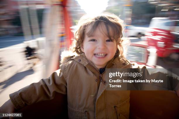 happy toddler spinning around in the carrousel - carousel foto e immagini stock