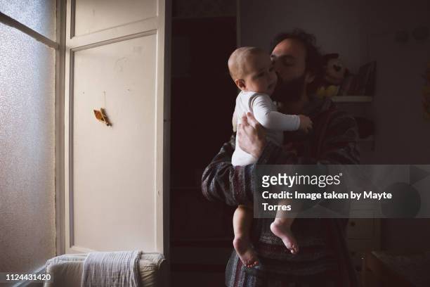 Dad kissing baby boy in the morning