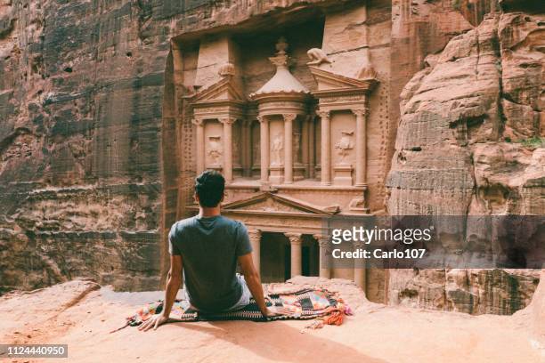hombre joven de senderismo en petra, jordania - petra fotografías e imágenes de stock