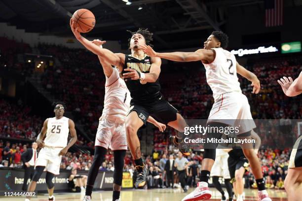 Carsen Edwards of the Purdue Boilermakers drives to the basket between Anthony Cowan Jr. #1 and Aaron Wiggins of the Maryland Terrapins during a...