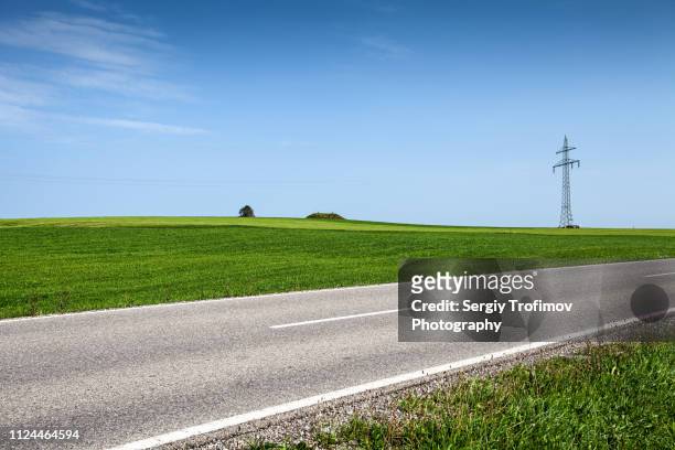 green field and road in summer day. bavaria, germany. - country road stock pictures, royalty-free photos & images