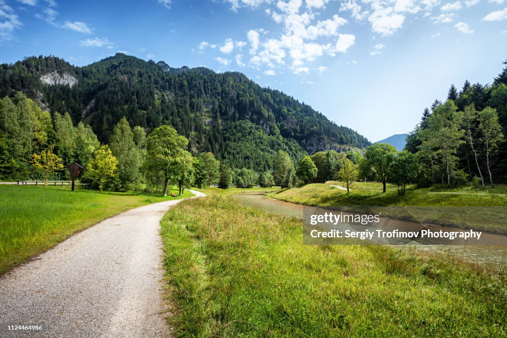 Dirt road along a river, summer landscape. Bavaria, Germany.