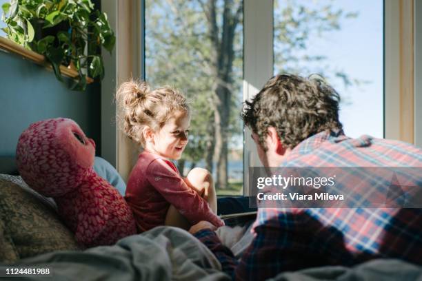 father and daughter talking in bed - girls in bedroom stock-fotos und bilder