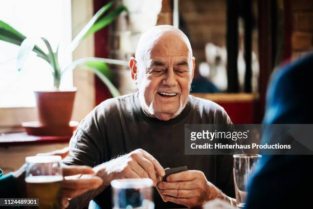 older man drinking with friends - senior men playing cards stock pictures, royalty-free photos & images