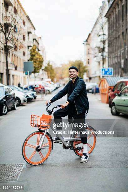 portrait of young man riding city bike - berlin people ストックフォトと画像