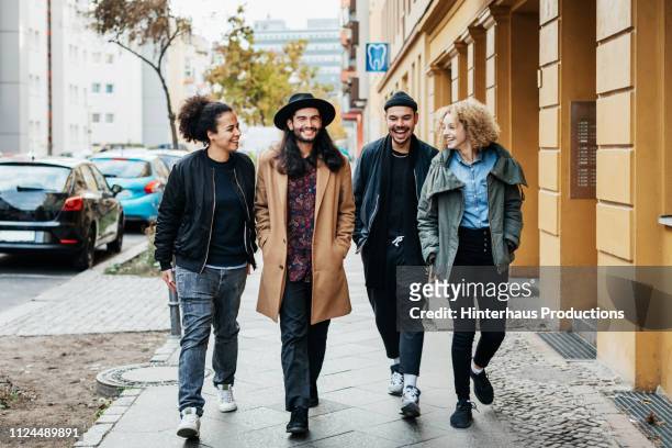 group of friends making way to a bar - four people stockfoto's en -beelden