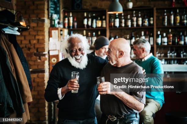 old friends catching up at craft beer bar - senior men beer stock pictures, royalty-free photos & images