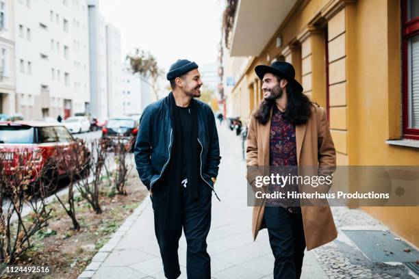 two friends on their way to bar together - zwart jak stockfoto's en -beelden