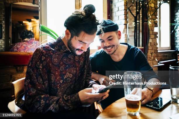 two hipster drinking together - man in bar stockfoto's en -beelden