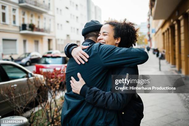 friends hugging in the street - hug imagens e fotografias de stock