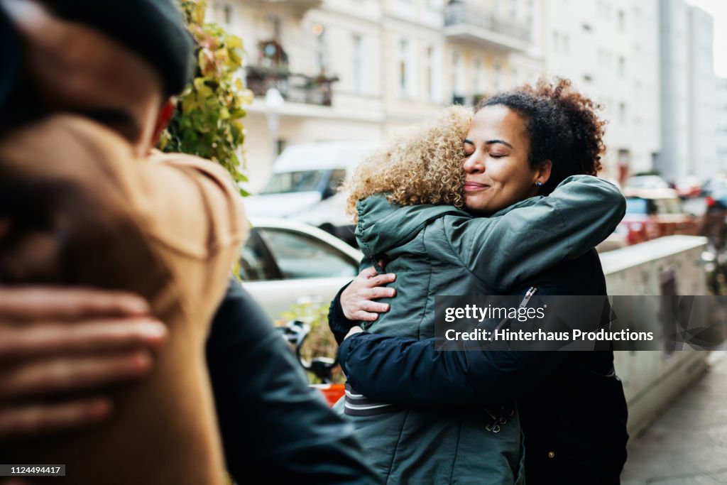 Friends Embracing In Street