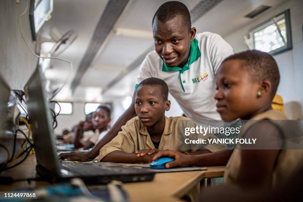 Schoolchildren from Avrankou-Houeze school attend a BloLab training in a container with the founder of this non-profit group Medard Agbayazon at...