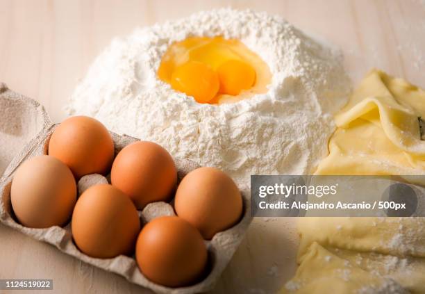 close up of eggs on tray on table with flour and pastry - alejandro ascanio stock-fotos und bilder