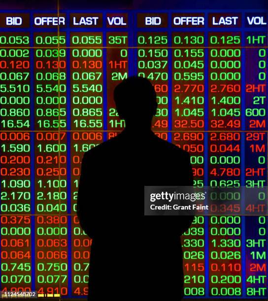 man standing before stock price display. - exchange rate bildbanksfoton och bilder