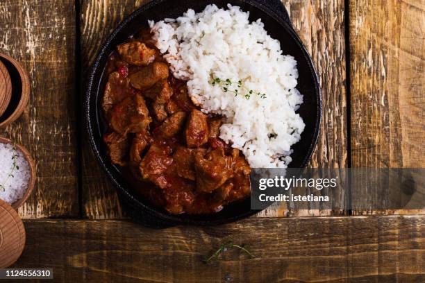 beef stew served with white rice in cast iron skillet - kalfsvlees stockfoto's en -beelden
