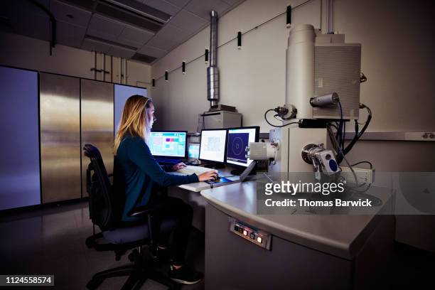 female scientist working with scanning electron microscope - microscopio elettronico a scansione foto e immagini stock