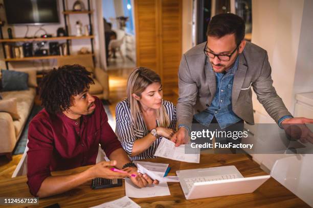 real estate agent helping a young couple with paperwork - insurance contract stock pictures, royalty-free photos & images