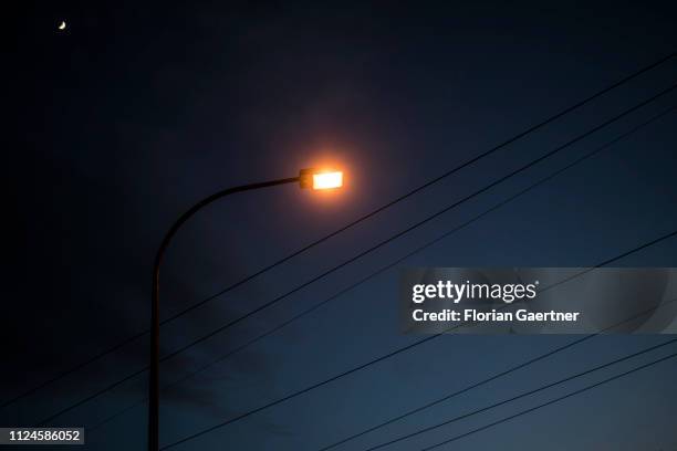 Street lamp is pictured in front of cables during blue hour on February 11, 2019 in Schwarzheide, Germany.