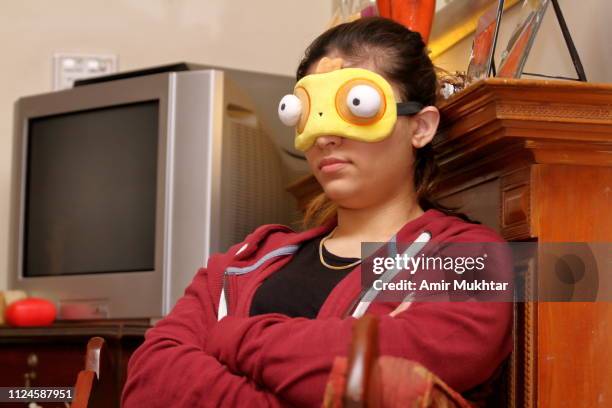 teenager girl wearing sleeping eye pad while sleeping in sitting position - masque pour les yeux photos et images de collection