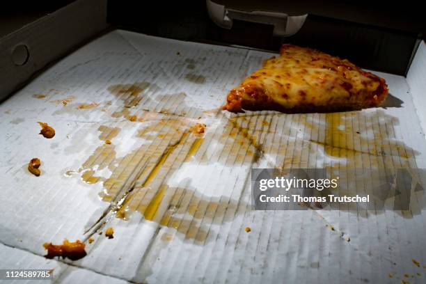 Berlin, Germany Symbolic photo on the subject of unhealthy food. A piece of pizza lies in a greasy pizza box on February 13, 2019 in Berlin, Germany.