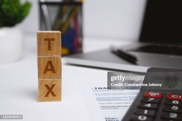 tax on wooden blocks on top of work desk space - tax law stock pictures, royalty-free photos & images